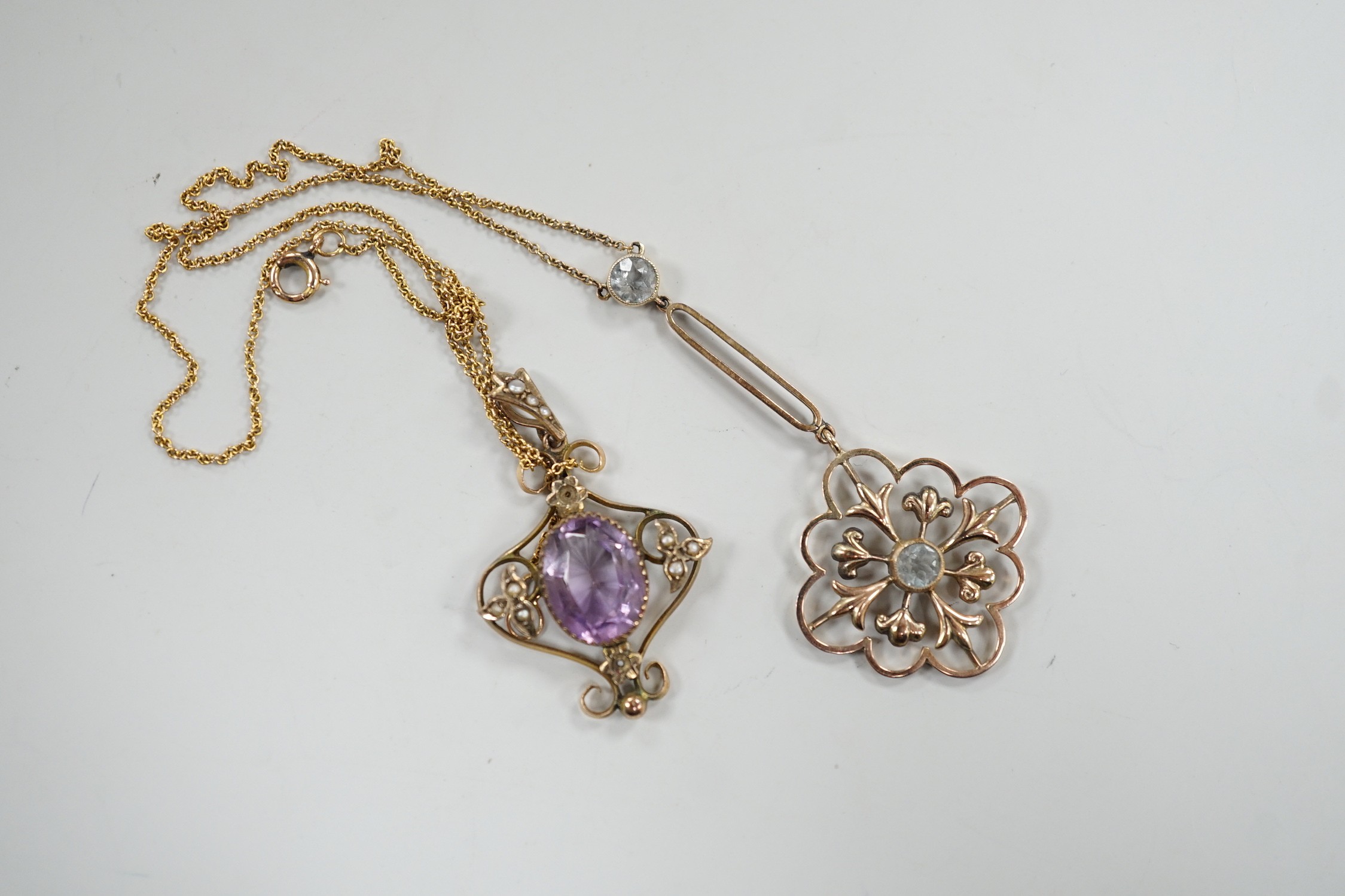 Two Edwardian 9ct and gem set pendants, including amethyst and seed pearl and two stone aquamarine drop, 53mm on a yellow metal chain, gross weight 6.3 grams.